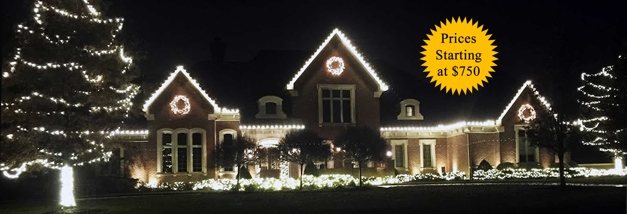 Large brick home outlined in warm white professional holiday lighting at night — prices starting at $750